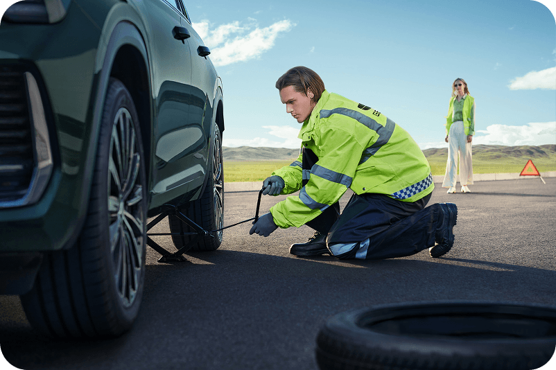 Assistant Geely changeant une roue au bord de la route